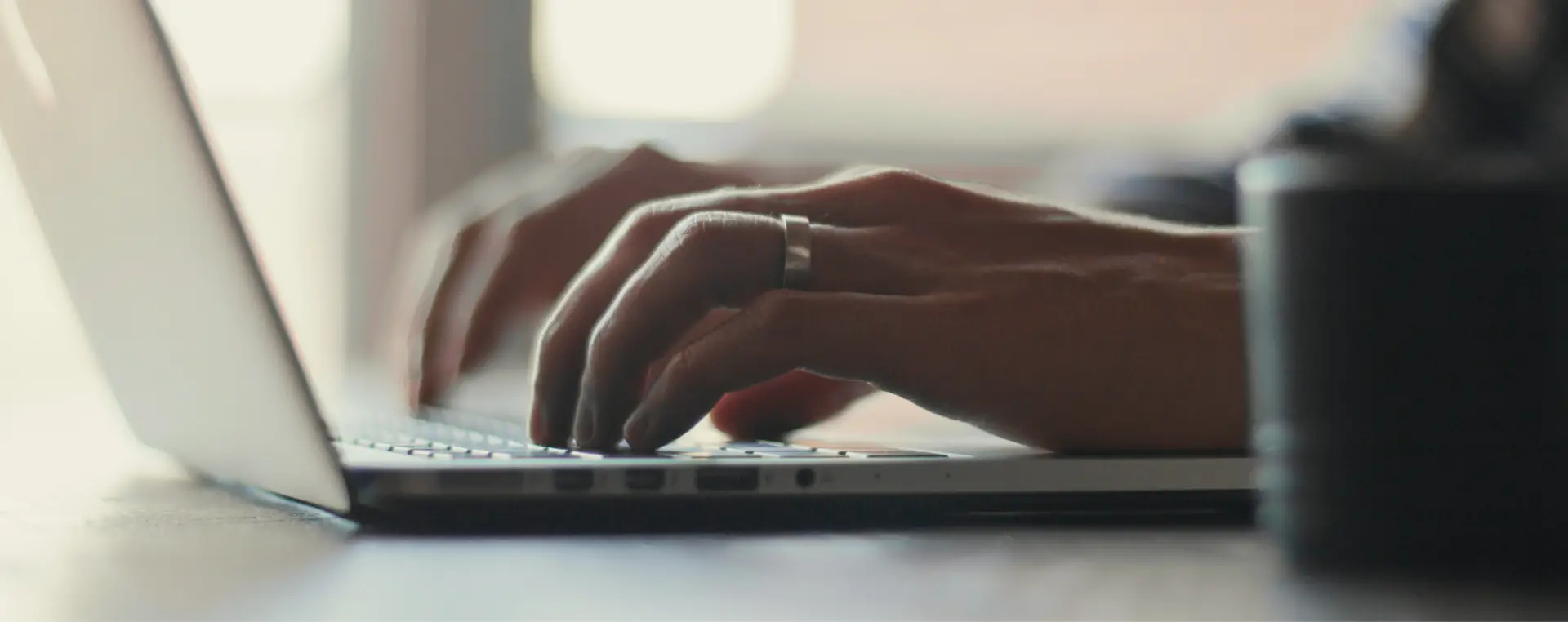 Close-up of hands typing on laptop keyboard