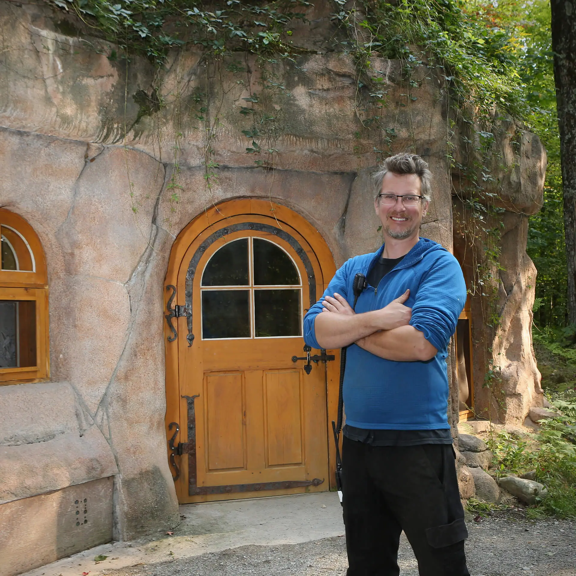 Homme souriant devant porte en bois rustique