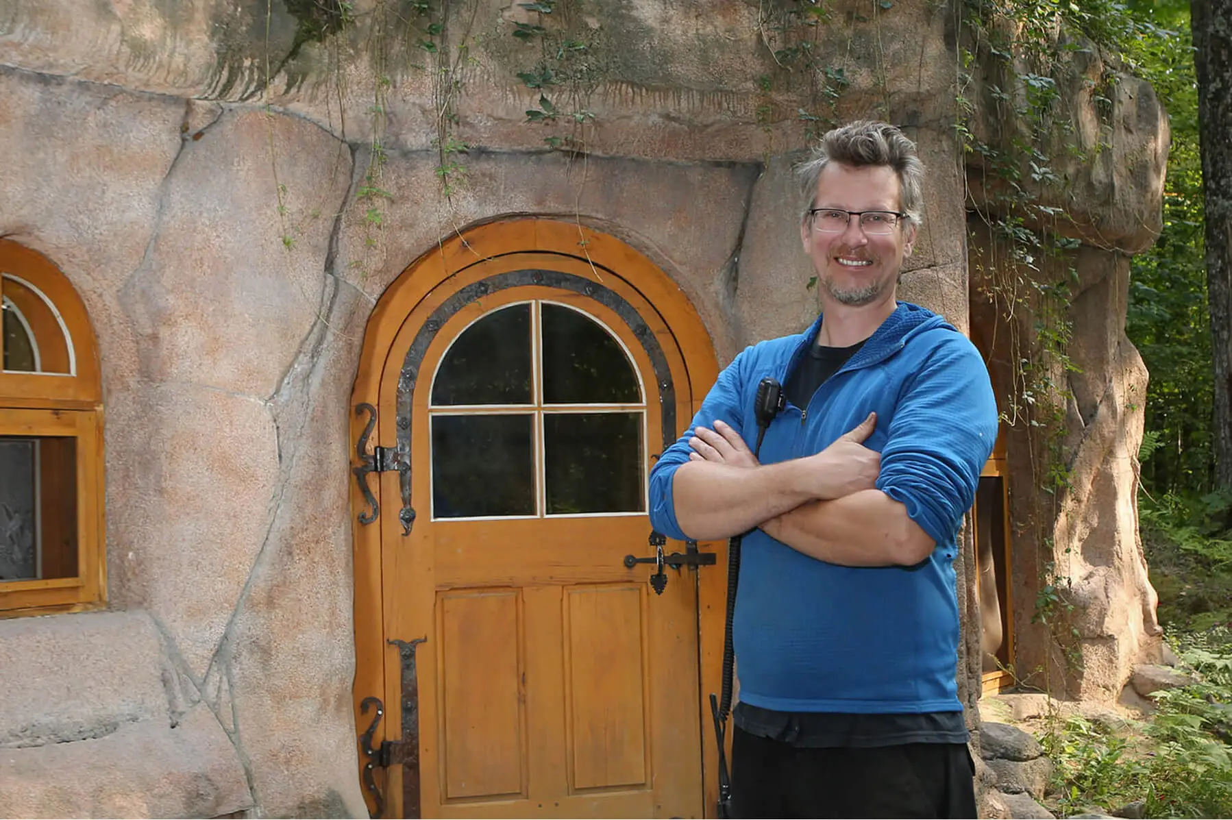 Smiling man in front of a rustic wooden door