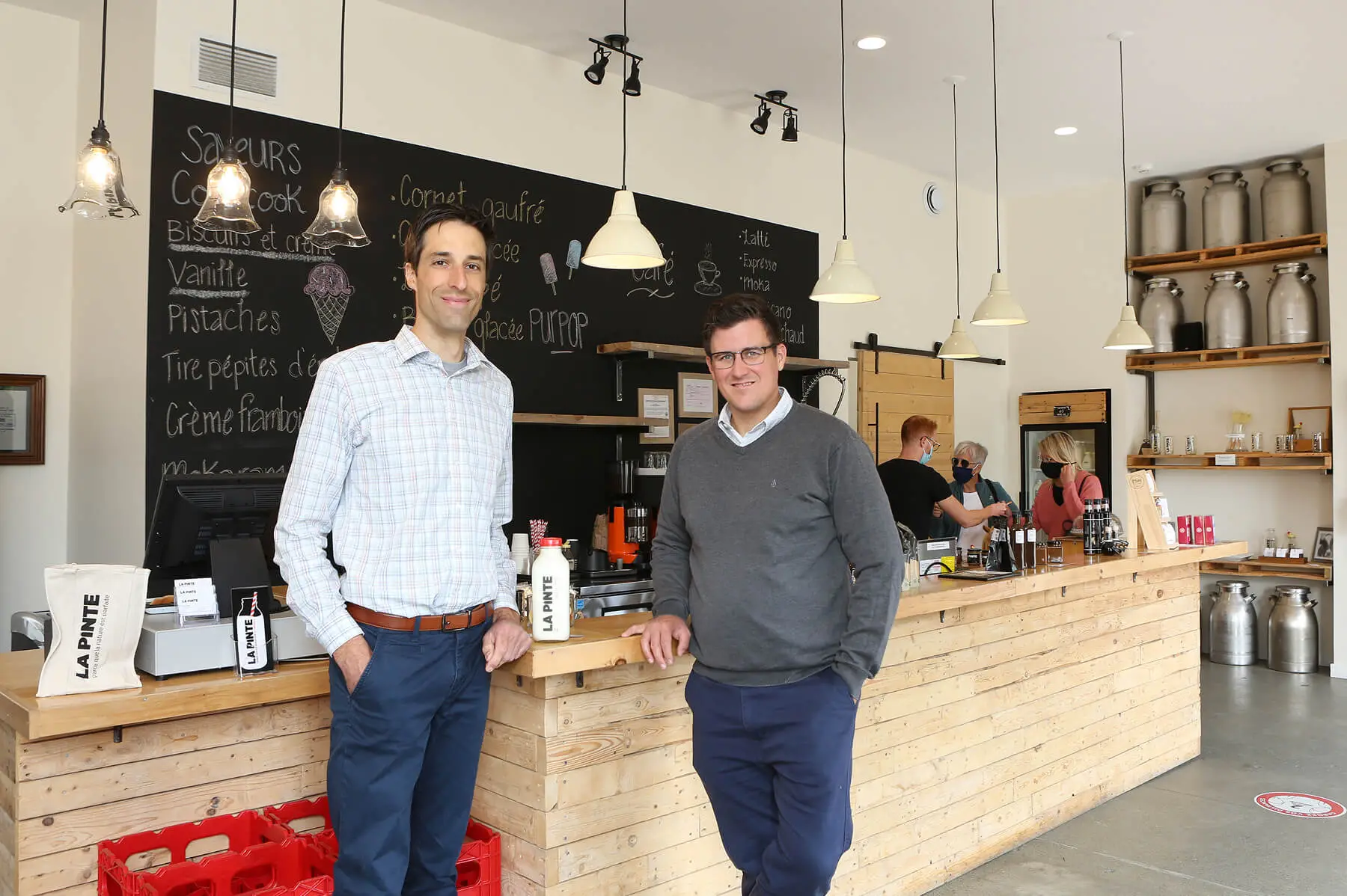 Deux hommes posant dans un café moderne