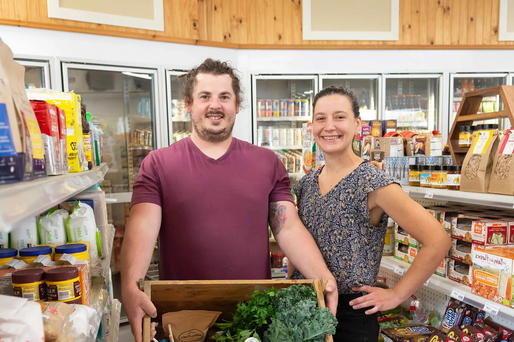 Smiling couple holding fresh produce in grocery store