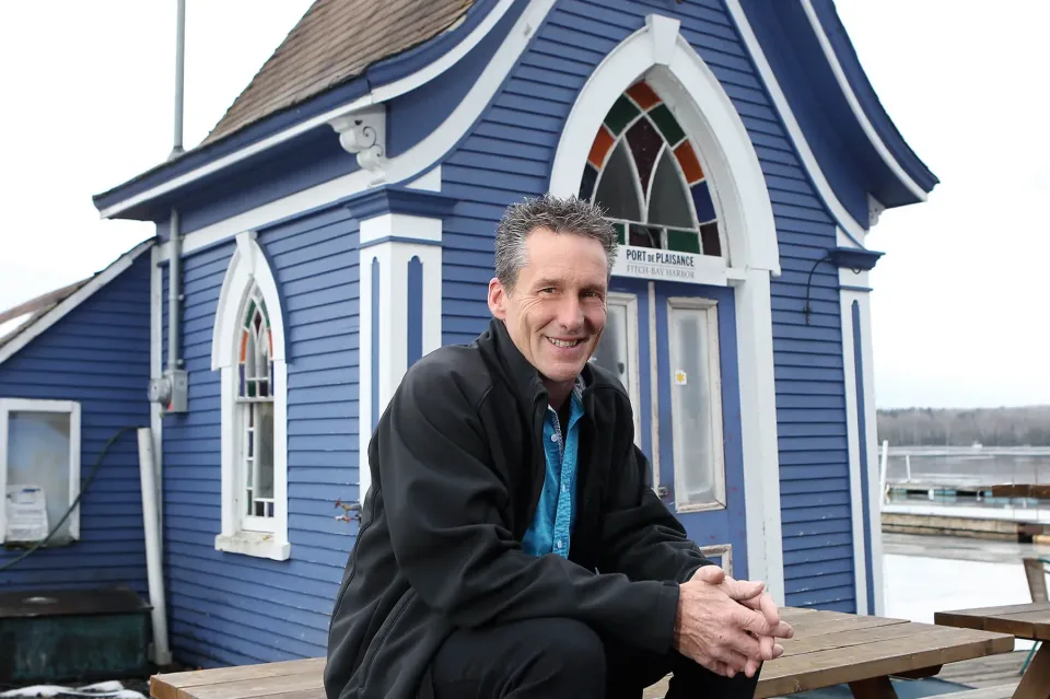 Homme souriant devant bâtiment bleu