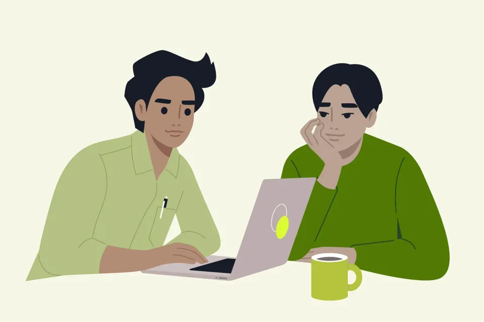 Two men working together on a laptop