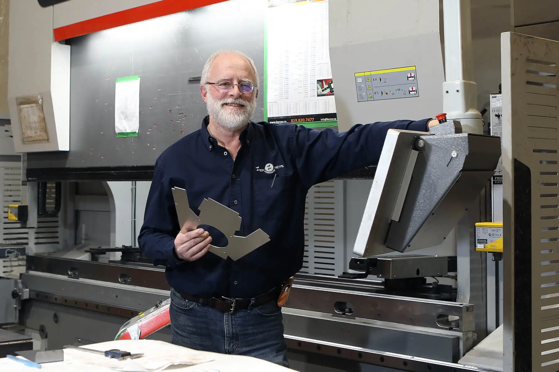 Technicien tenant pièce métallique dans atelier industriel