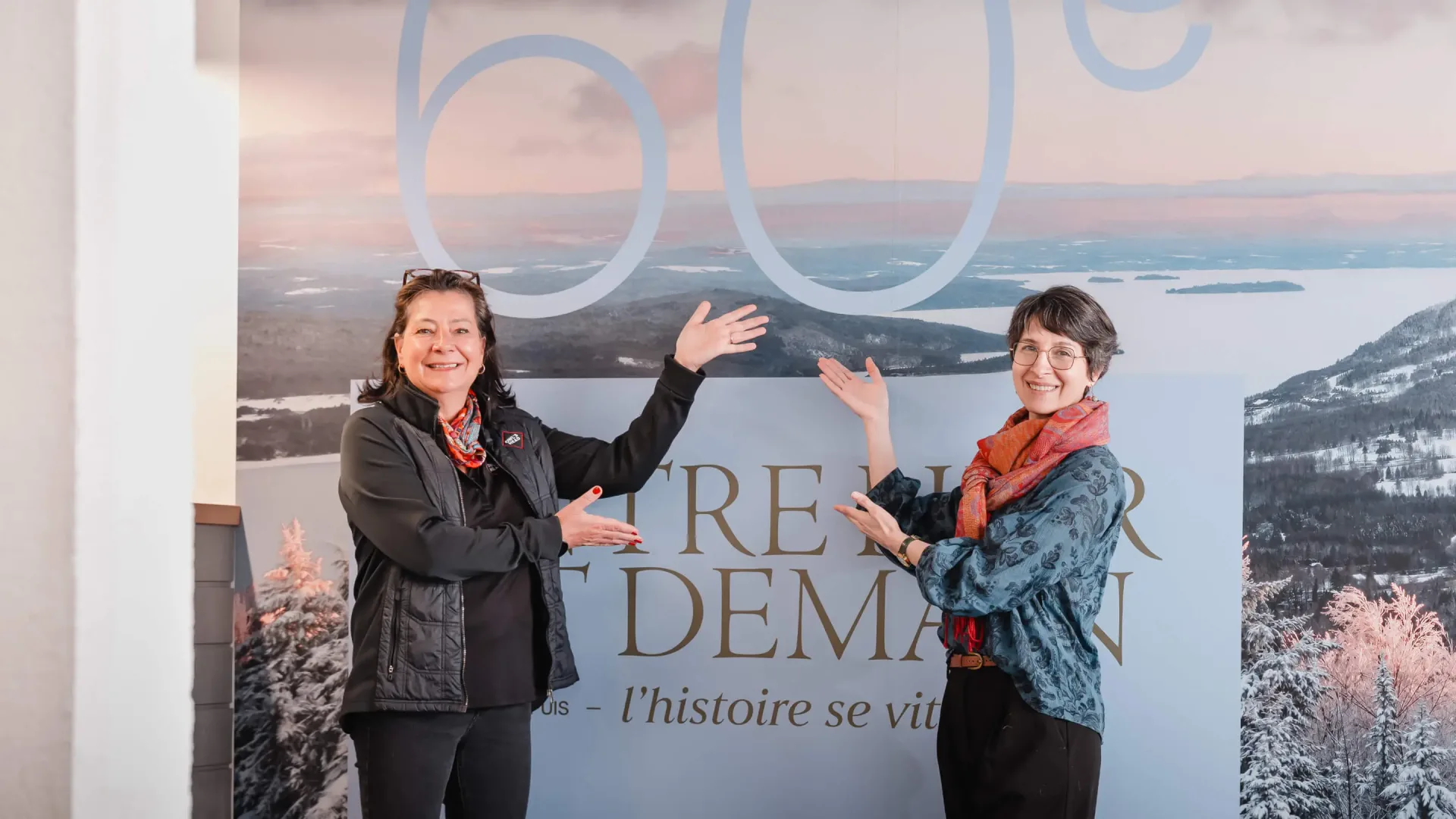 Deux femmes présentant un panneau de paysage montagneux