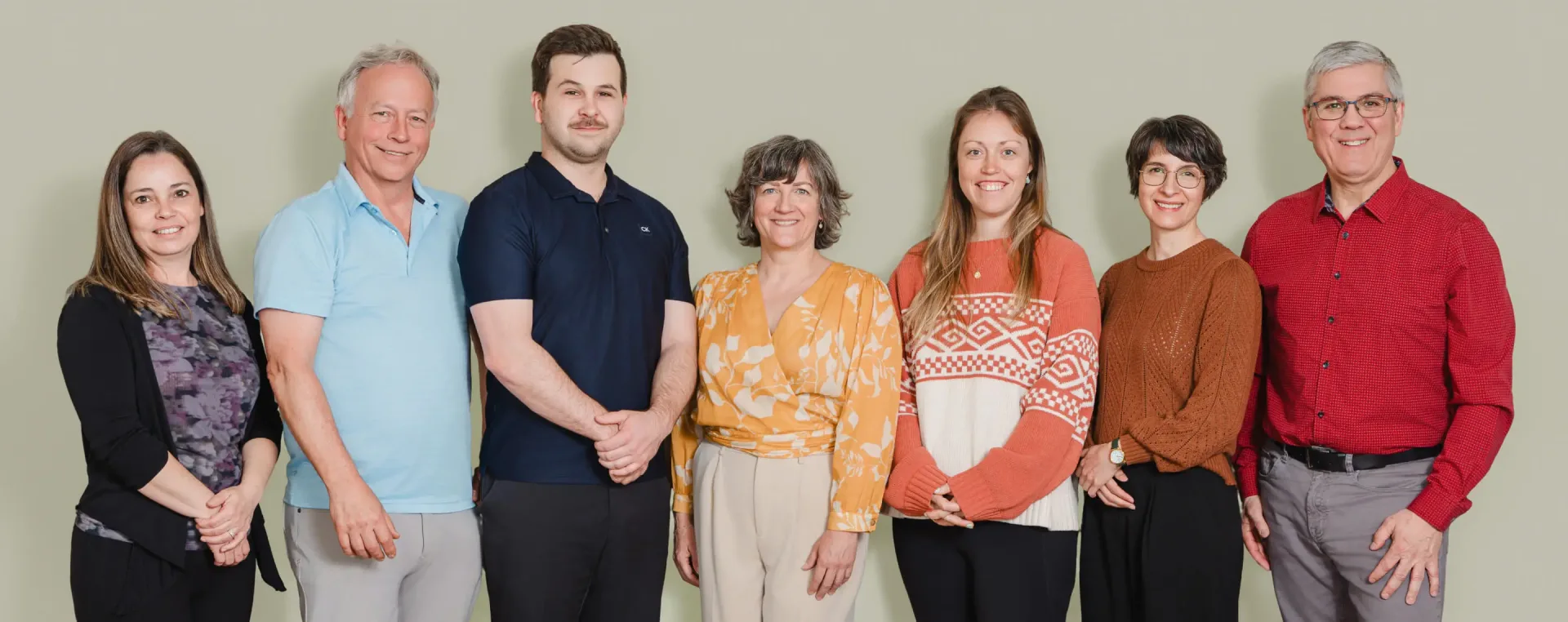 Groupe de sept adultes souriants en intérieur